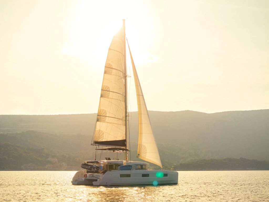 Naya a sailing catamaran, sailing in adriatic sea during sunset.