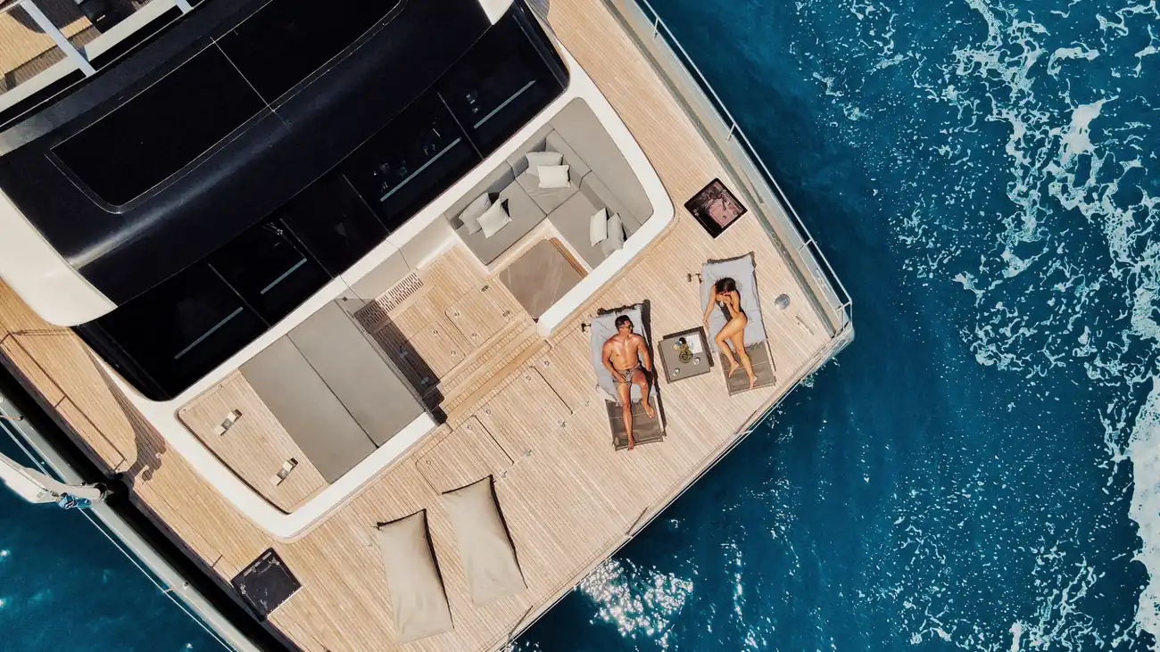 A croatia catamaran charter captured from above, and a couple tanning on the deck.