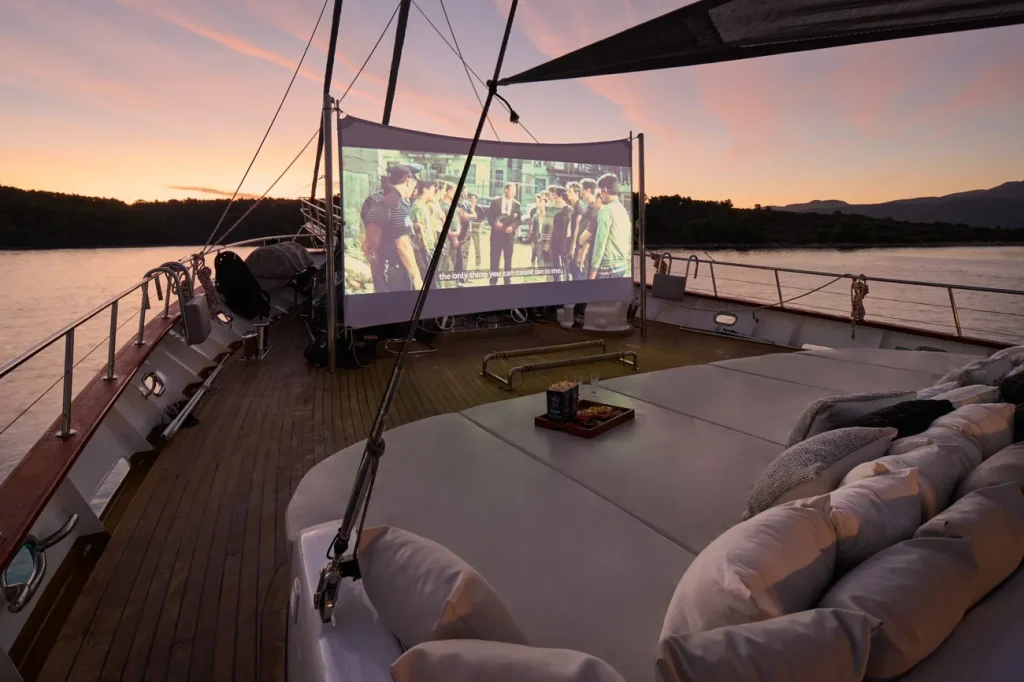 A yacht charter deck with a big screen for watching movies during evening for big groups